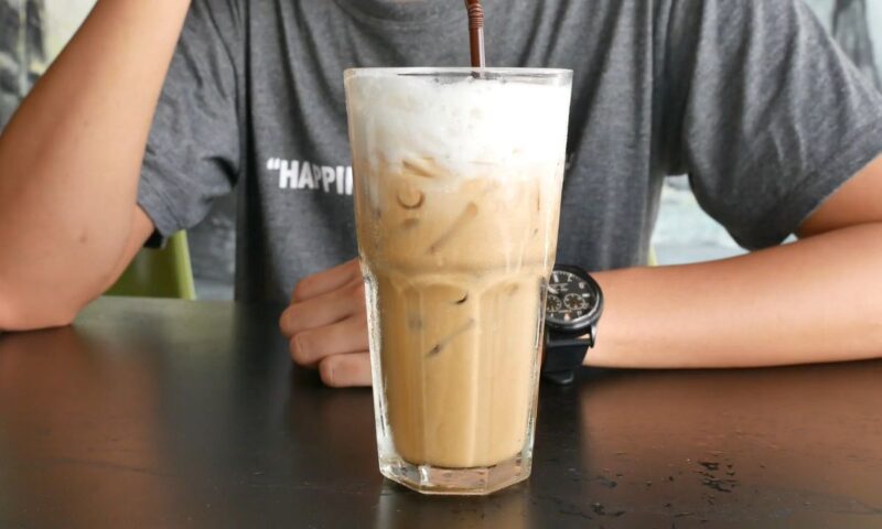 momak pije hladnu kafu sa šlagom