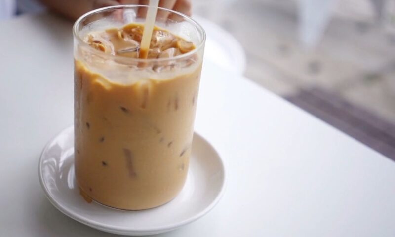 osoba meša sa slamčicom hladnu kafu